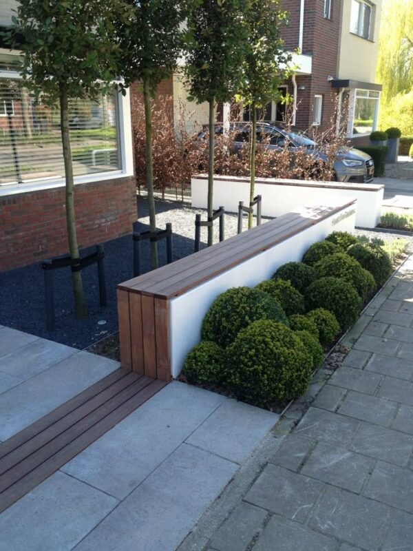 Voortuin inspiratie rijtjeshuis: voortuin met houten bankje en bomen 